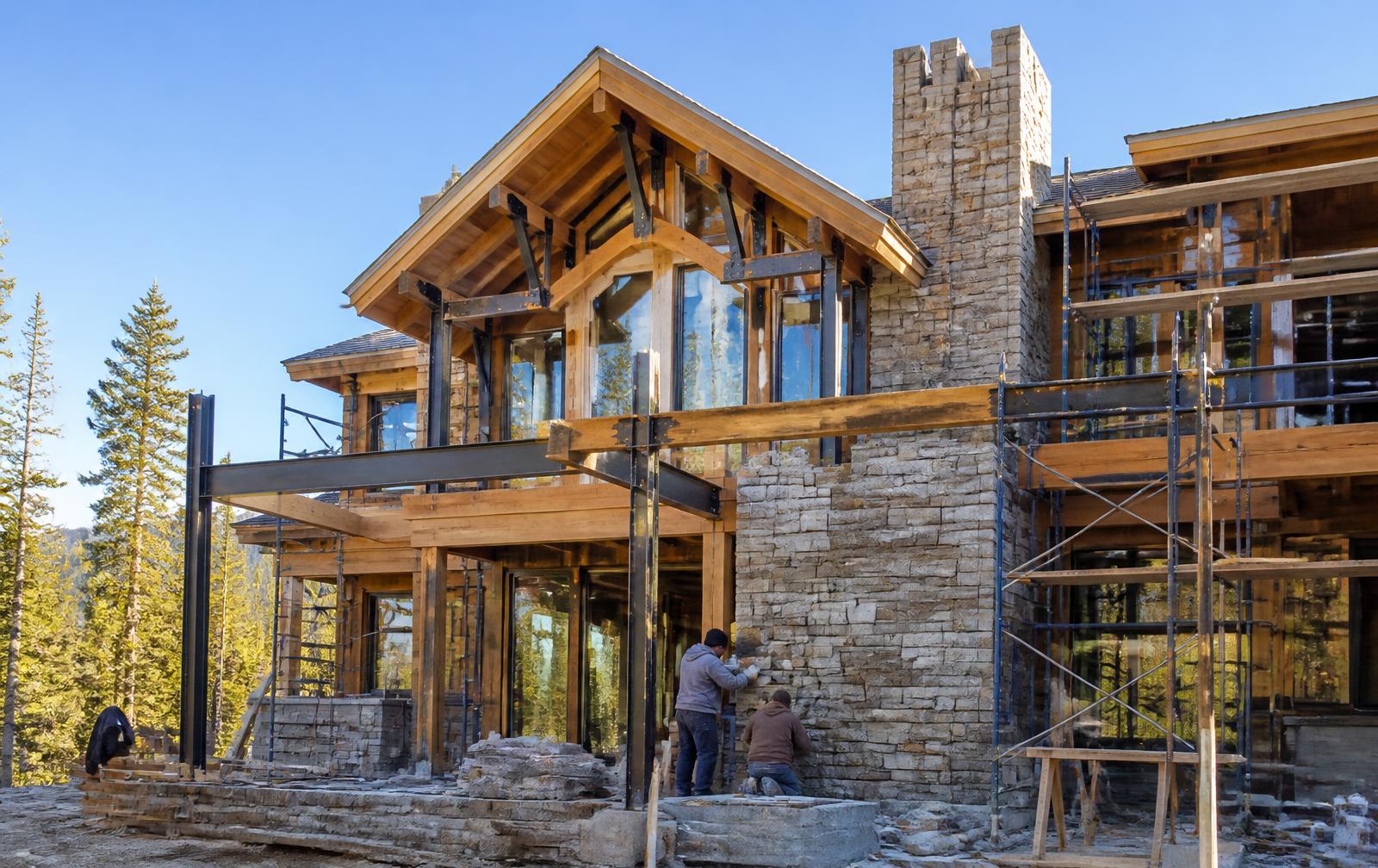 A custom Foxcroft home under construction with timber framing and stone masonry