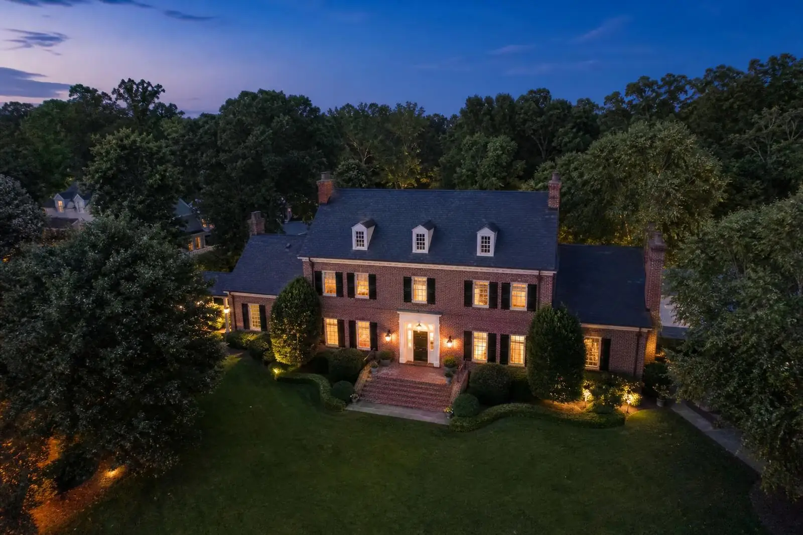 Modern luxury Foxcroft estate at twilight with reflecting pool