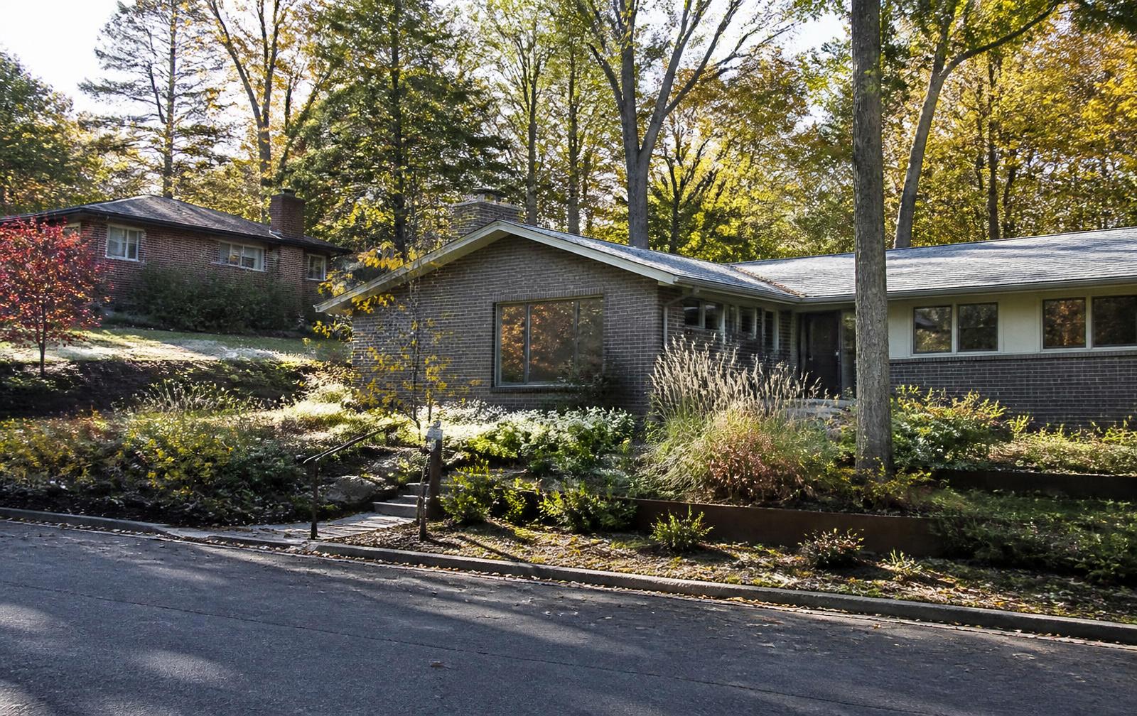 Wooded hillside street with midcentury brick homes in Foxcroft Hills, Charlotte